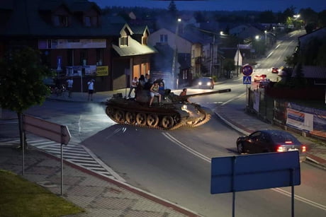 A group of drunk guys (including the driver) driving a Soviet T-55 tank to a liquor store, to buy some beer. Pajeczno, Poland (2019).