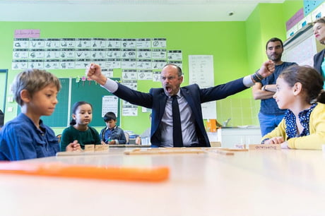 French Prime Minister &Eacute;douard Philippe defeats children in a game of dominos during a visit to a school, July 2020.